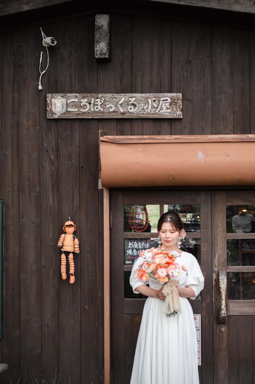 コロボックルヒュッテ入口でブーケを持つ花嫁
